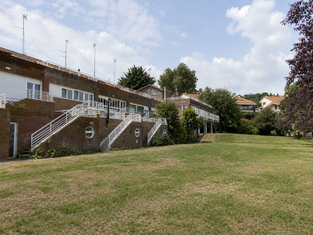 Edificio de apartamentos con terrazas y jardín delantero