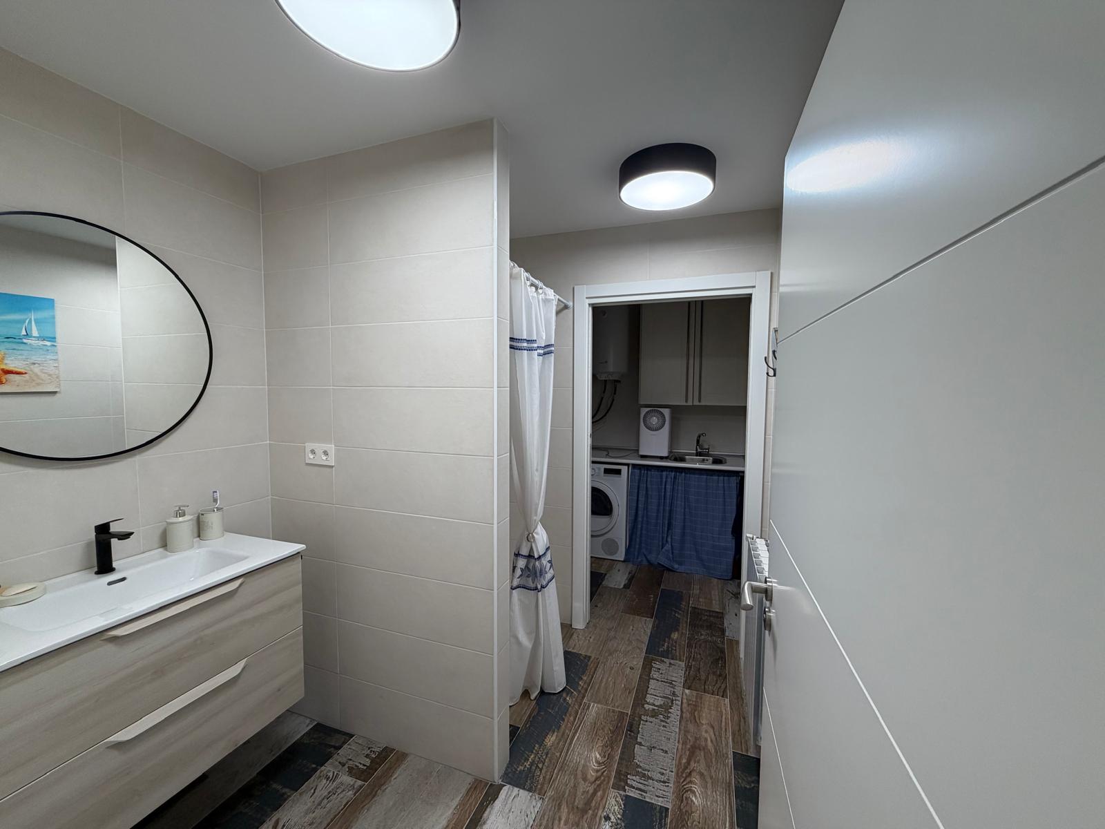Baño con lavabo y lavadora en piso