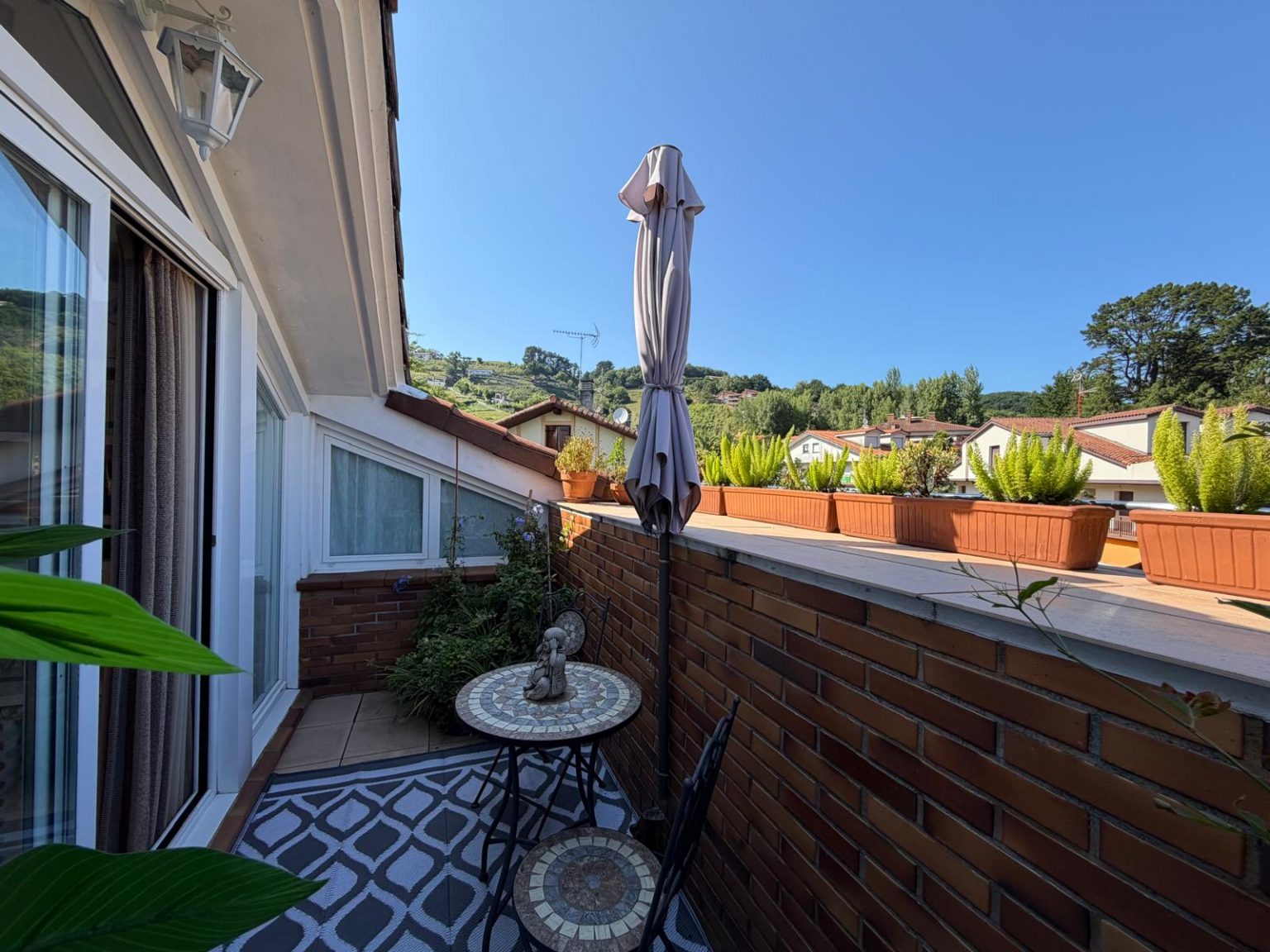 Terraza con mesa y sombrilla