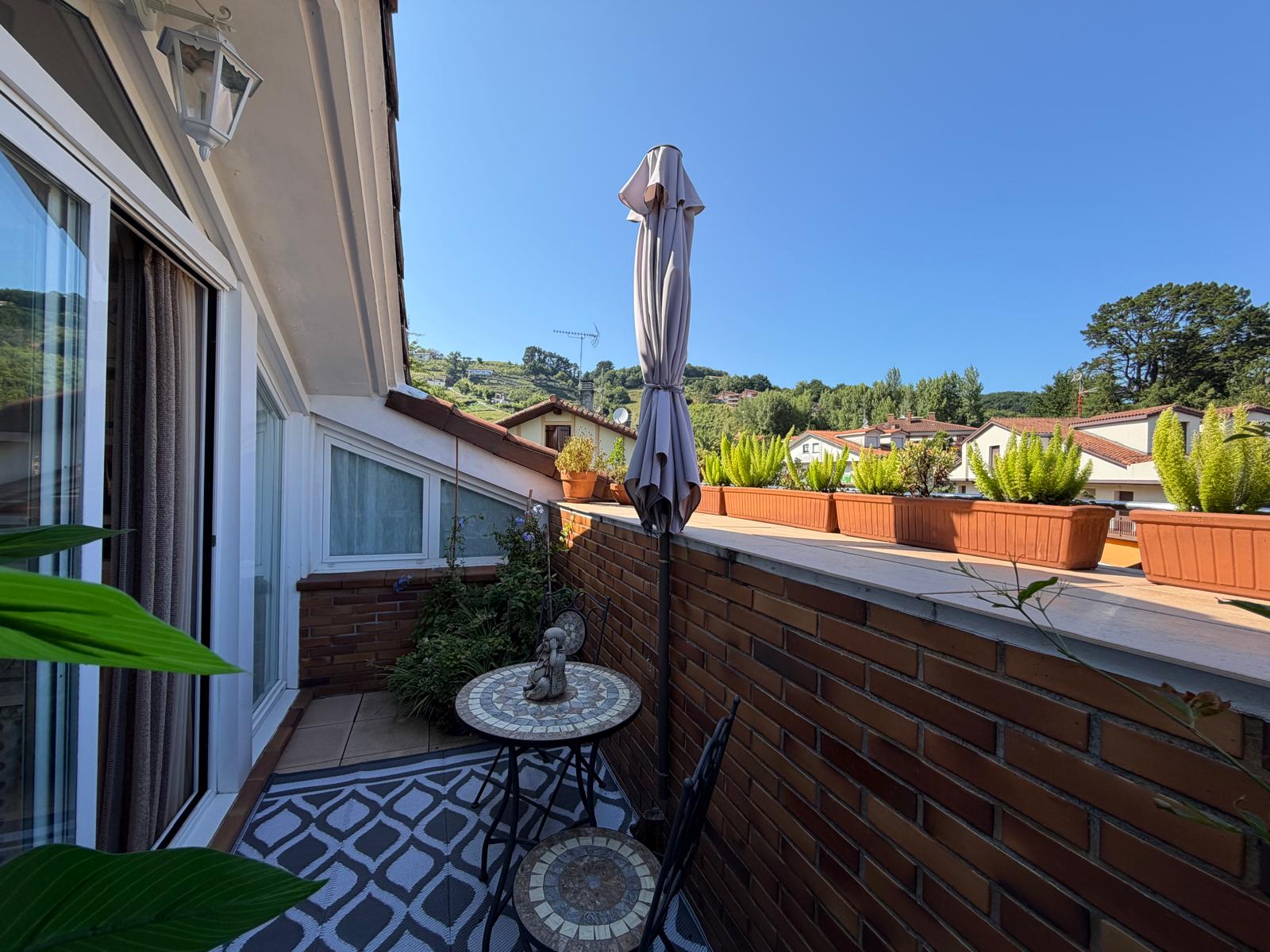 Terraza con mesa y sombrilla