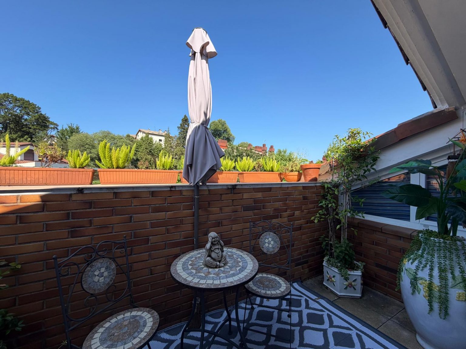 Terraza con mesa y sombrilla