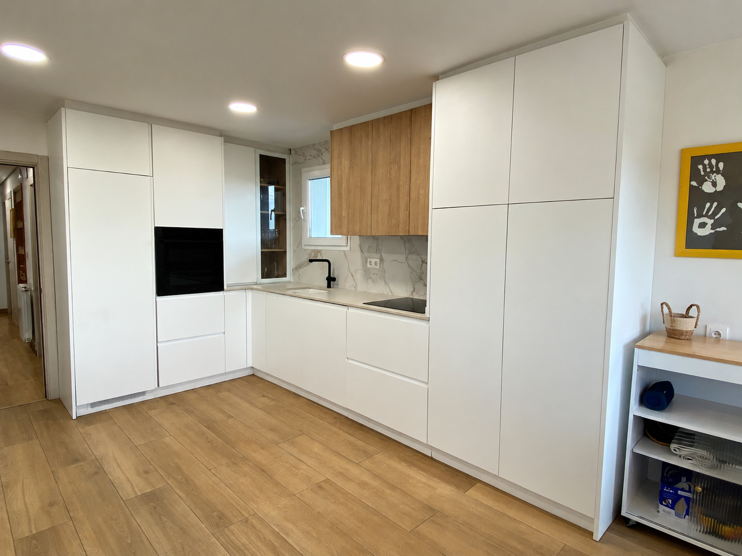 Cocina moderna con muebles blancos y madera