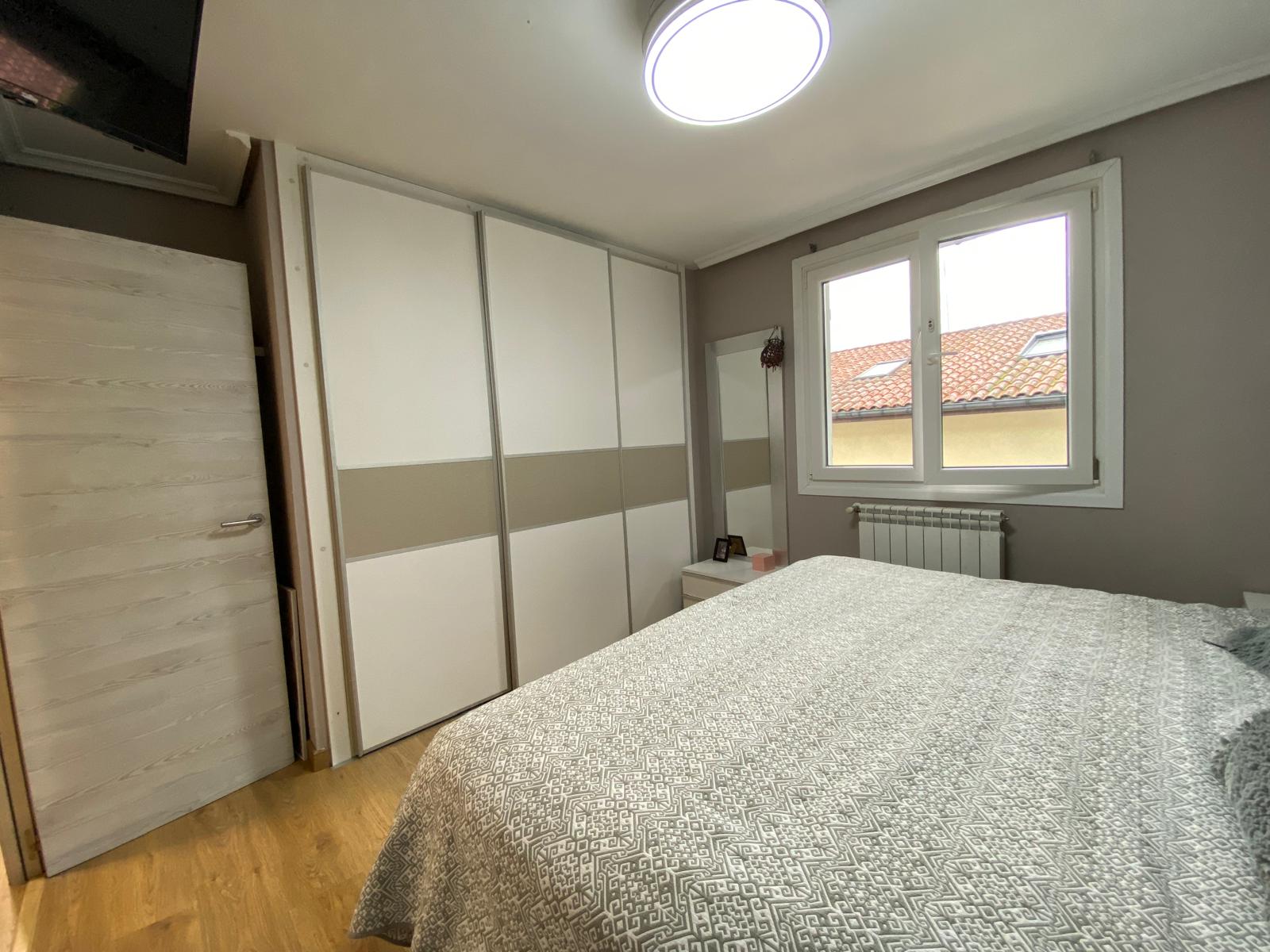 Dormitorio con armario y decoración neutra
